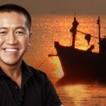 Comedian Anh Do with a boat in the background.