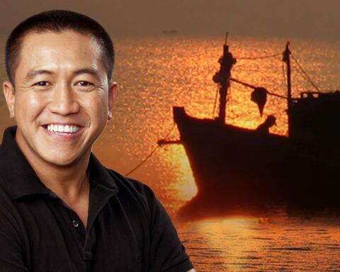 Comedian Anh Do with a boat in the background.