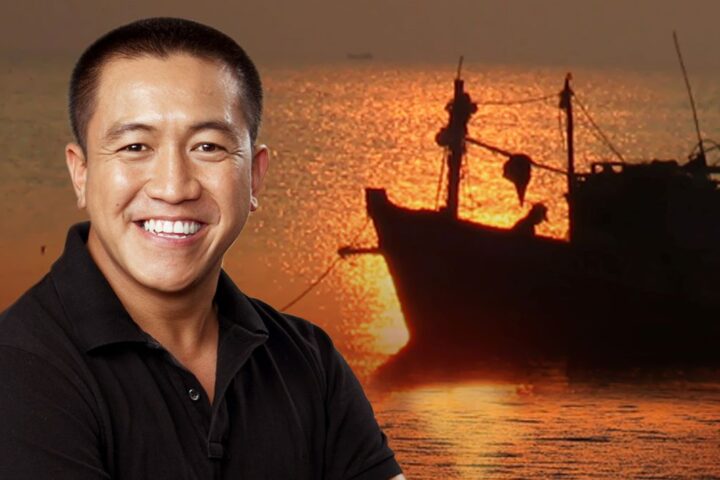 Comedian Anh Do with a boat in the background.