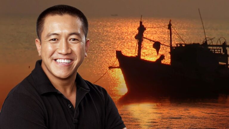 Comedian Anh Do with a boat in the background.