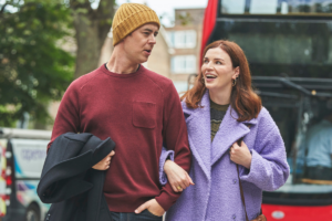 Actors in the film, And Mrs, walk hand in hand on the street.