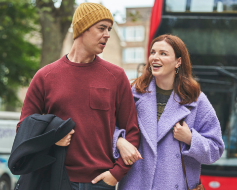 Actors in the film, And Mrs, walk hand in hand on the street.