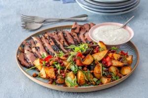 BBQ pomegranate roast lamb with vegetables on a plate.