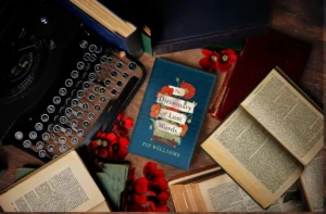 A typewriter, stacked books, and a bouquet of flowers elegantly arranged on a wooden table.