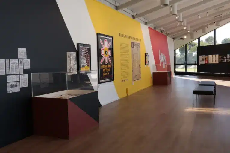 A museum interior featuring a large wall adorned with diverse posters and informative displays.