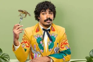 A man in a bright yellow suit holds a fork and knife, ready to enjoy a meal.