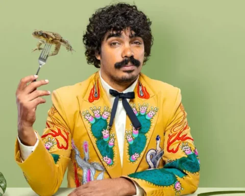 A man in a bright yellow suit holds a fork and knife, ready to enjoy a meal.