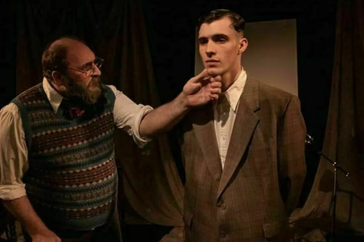 Two men stand together in front of a stage, ready to enjoy the performance ahead.