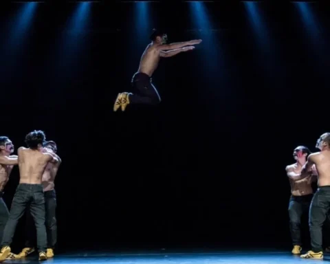 A group of men performing acrobatics in mid-air on a stage, showcasing their skills and teamwork.