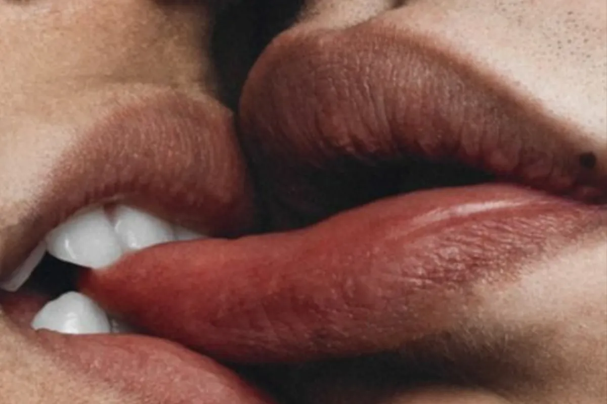 A close-up of two people sharing a tender kiss, capturing their affection and connection in a moment of intimacy.