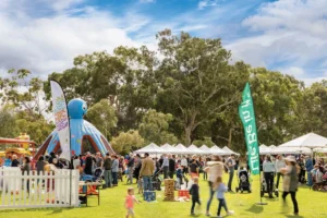 A diverse crowd gathers at an outdoor event, enjoying the atmosphere and engaging in various activities.