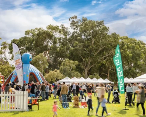 A diverse crowd gathers at an outdoor event, enjoying the atmosphere and engaging in various activities.