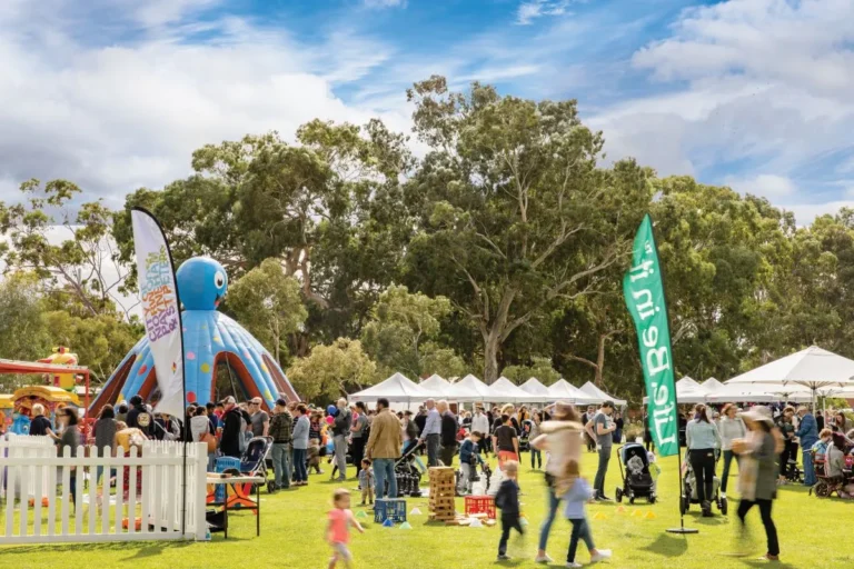 A diverse crowd gathers at an outdoor event, enjoying the atmosphere and engaging in various activities.