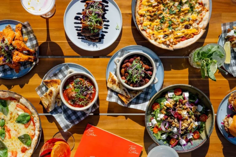 A table filled with a variety of dishes, including fruits, vegetables, meats, and desserts, showcasing a colorful spread.